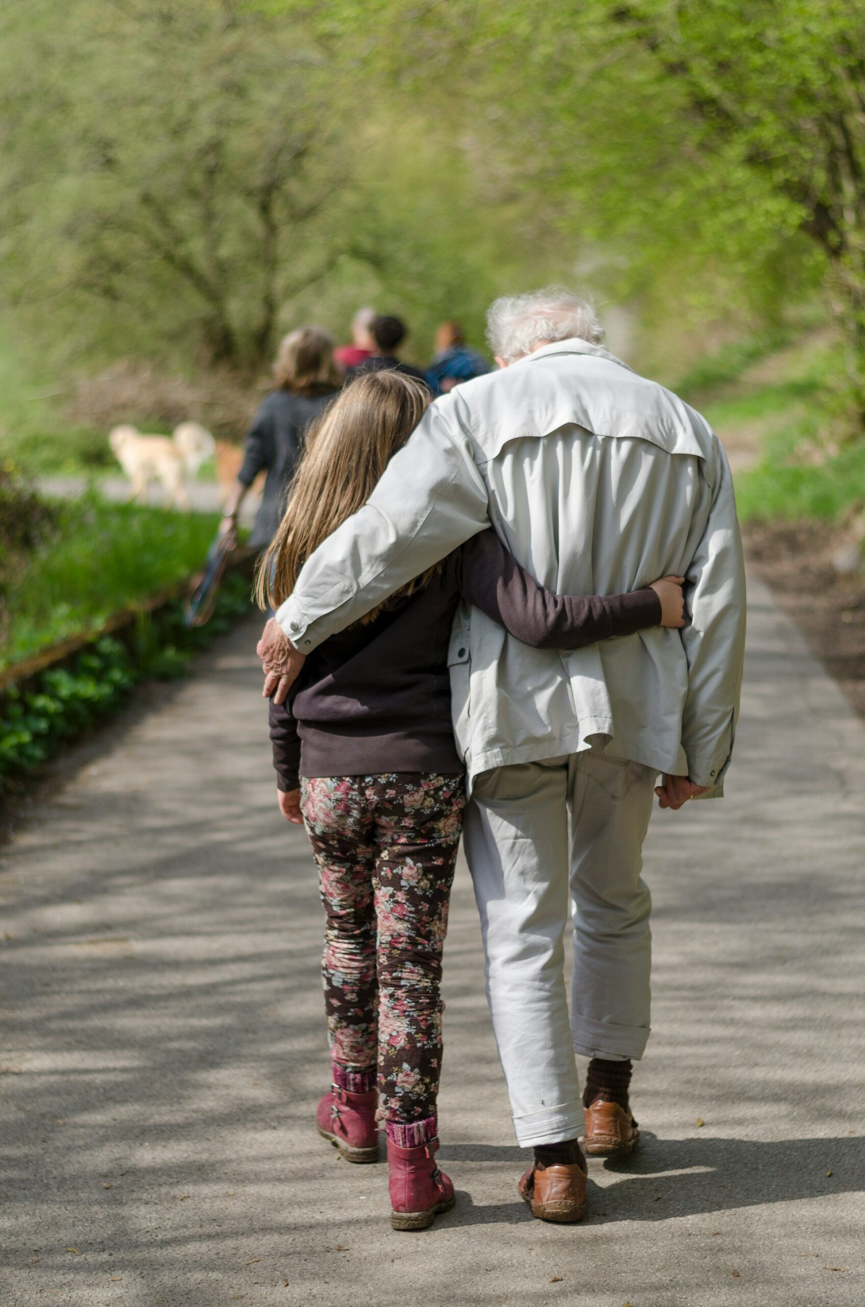 A young girl walking with her grandpa